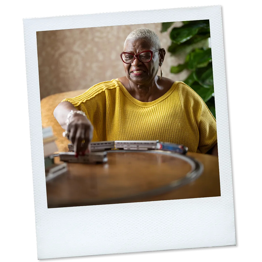 Polaroid of Joy, a real TAVR patient, playing with model trains