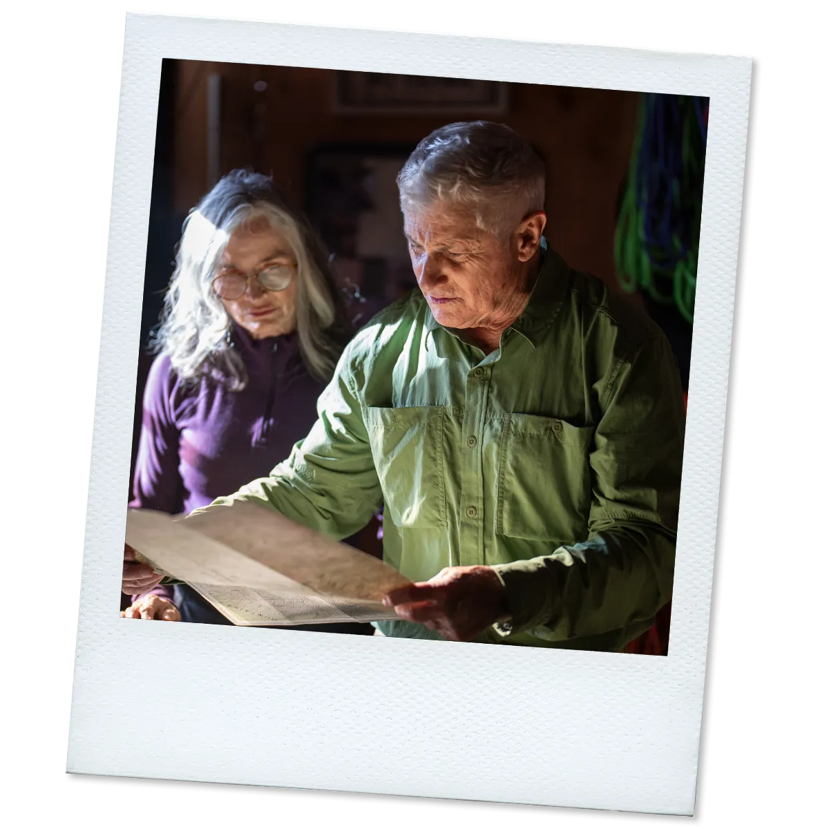 Polaroid of James, a real TAVR patient, looking at a map with a woman in the background