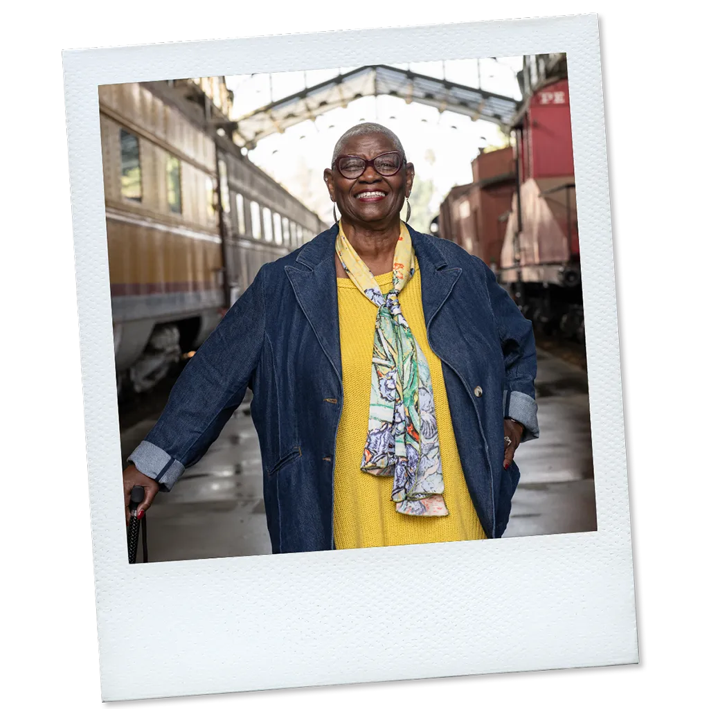 Polaroid of Joy, a real TAVR patient, standing in a train station